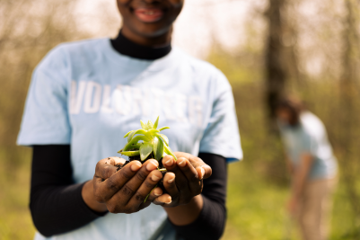 un adolescent afro americain defend l ecologie en tenant une petite plante - Écologie et climat